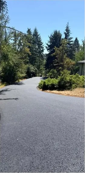 The driveway after paving: smooth black asphalt